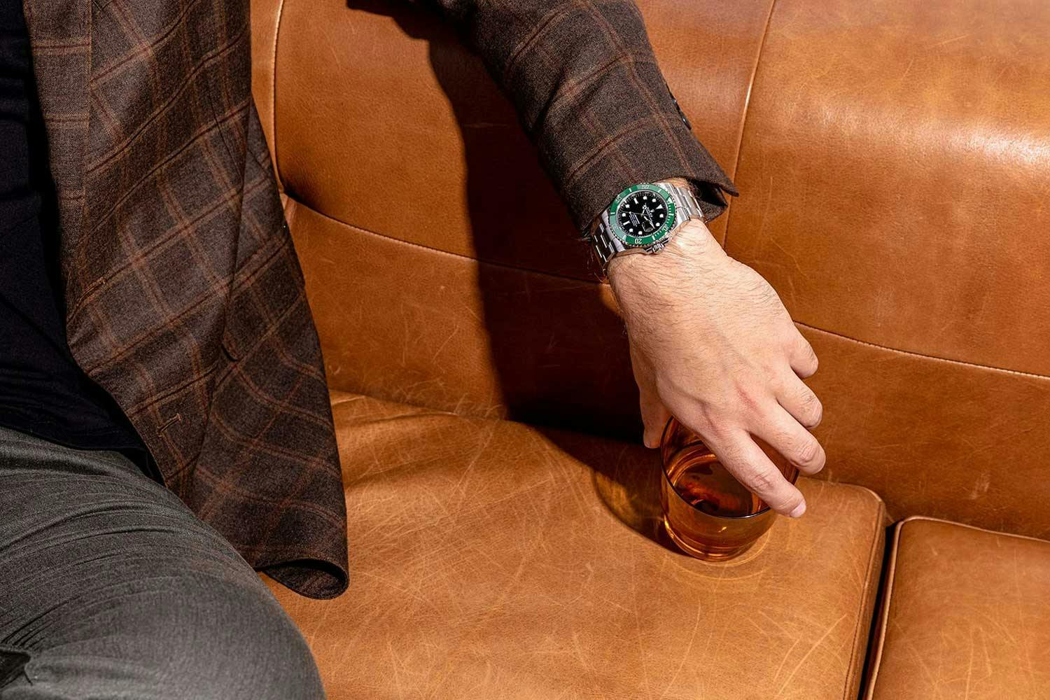 man wearing Rolex sitting on leather couch